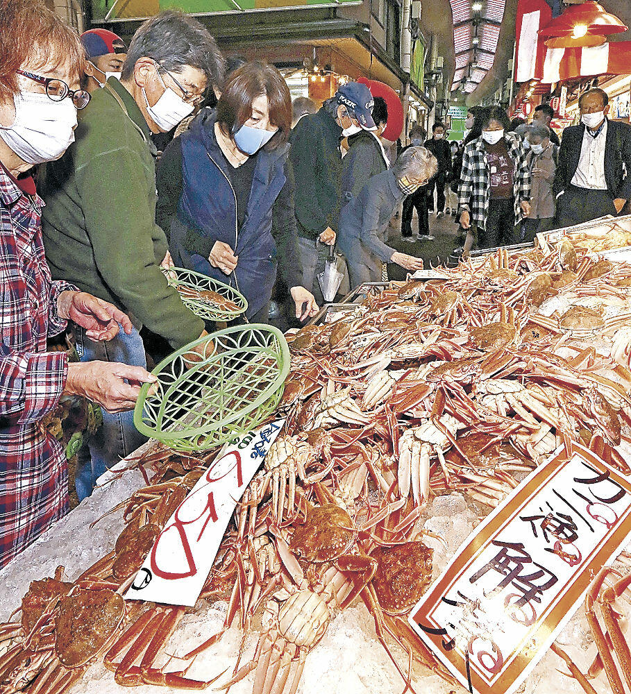 ずらりと並んだコウバコガニを品定めする買い物客＝金沢市の近江町市場
