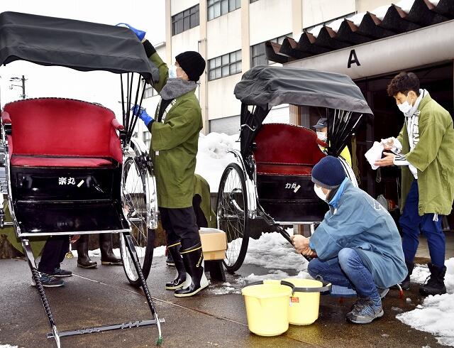 丁寧に人力車を掃除する「越前こぶし組」のメンバー＝１２月２７日、福井県大野市元町