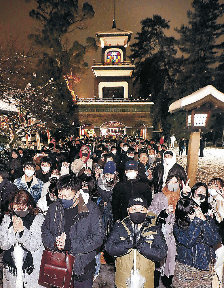 新年の幸福を願い、手を合わせる参拝者＝１日午前０時、金沢市の尾山神社