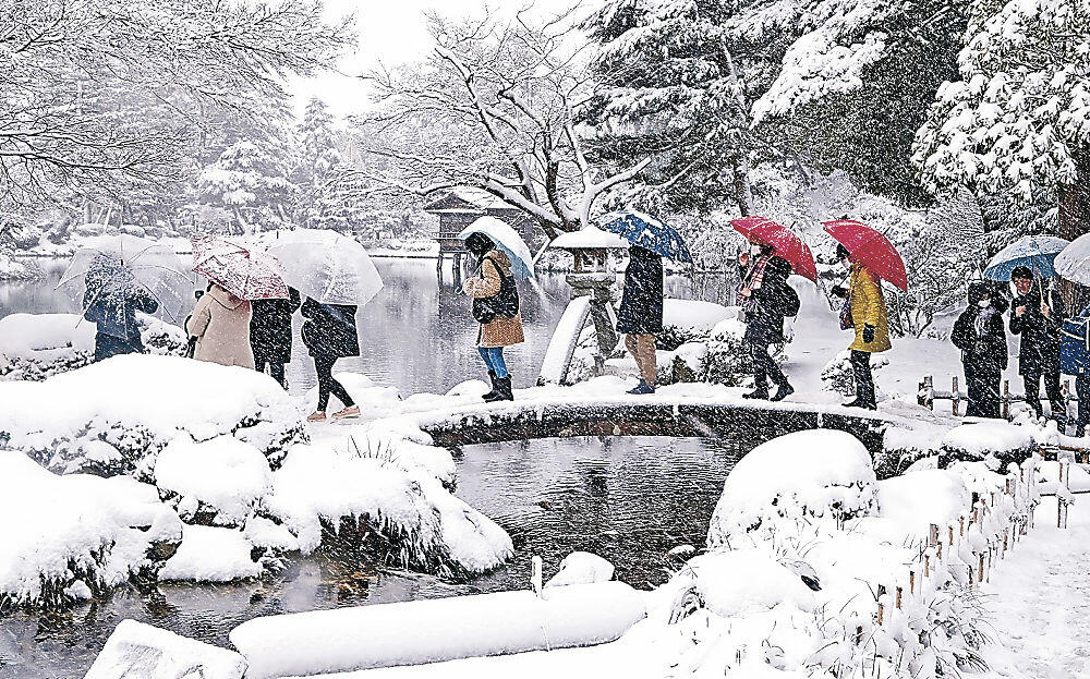 雪に包まれた名園を散策する観光客＝兼六園