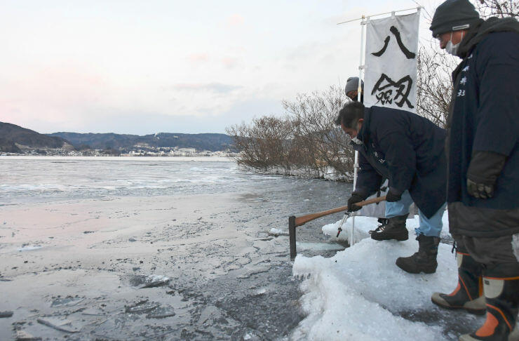 結氷した湖面から氷を切り出す氏子総代ら＝１０日午前６時５３分、諏訪市の諏訪湖