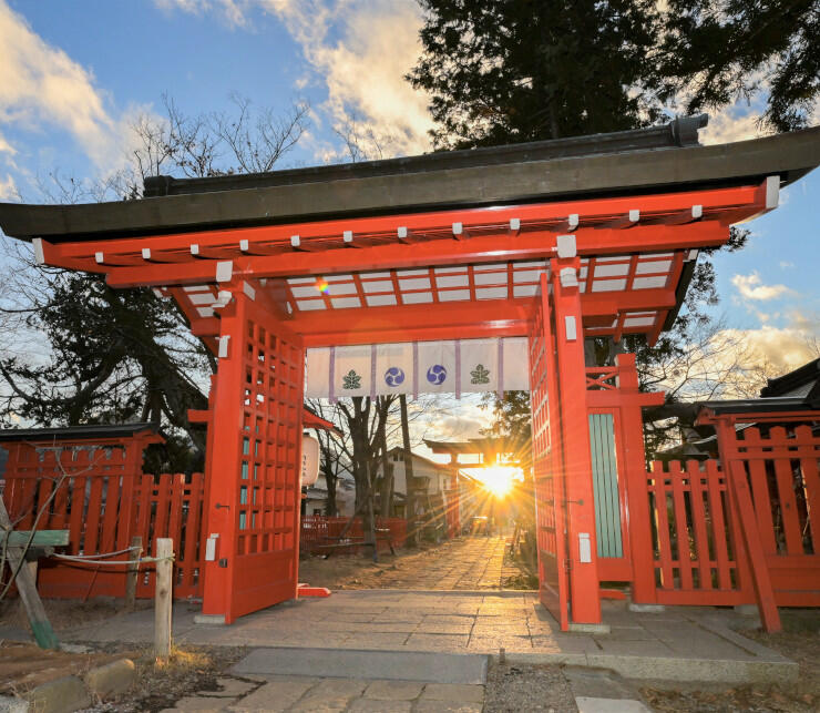 日本遺産の文化財の一つである生島足島神社。冬至とその前後には夕日が西鳥居（奥）と西御門（手前）越しに沈む＝２０２０年１２月１７日