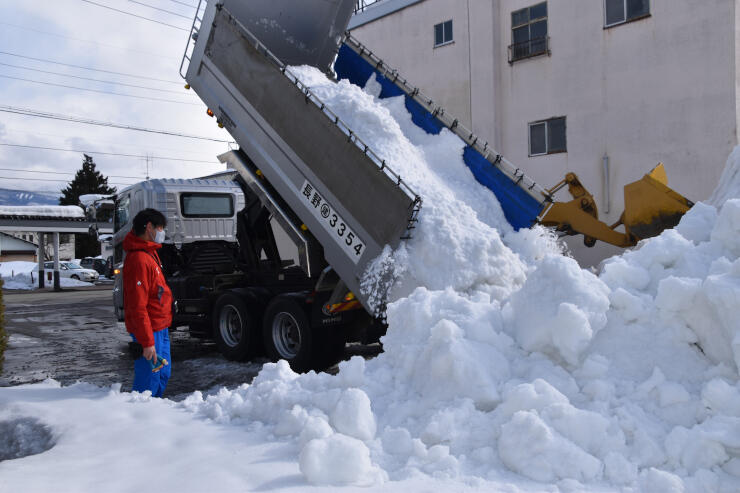 大型雪像を造る会場に雪を搬入する実行委員ら