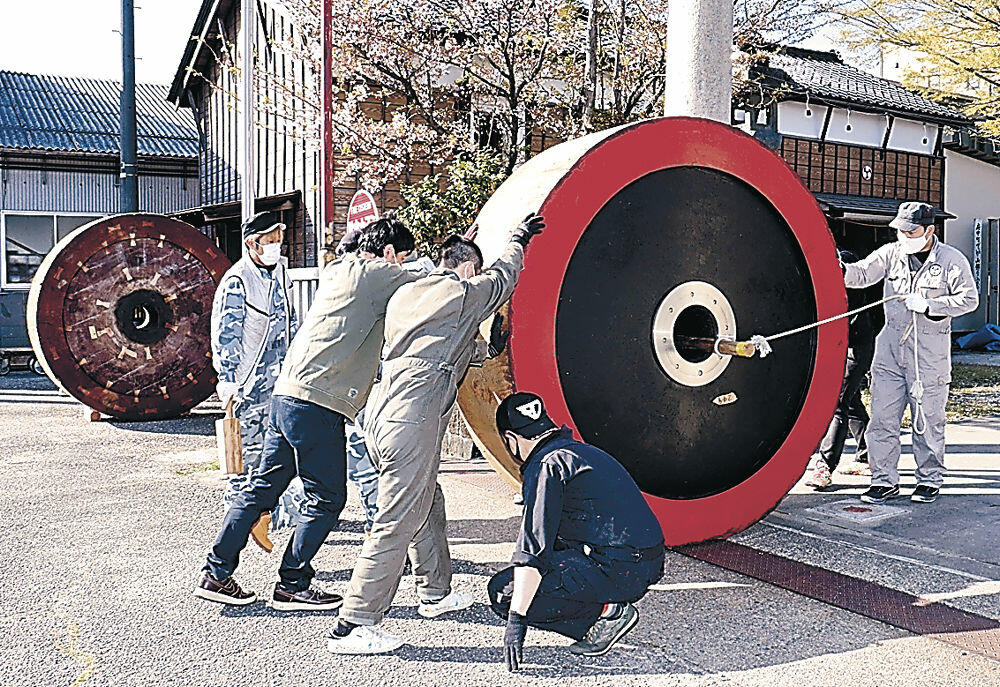巨大な車輪を運び出す若衆＝七尾市府中町の印鑰神社