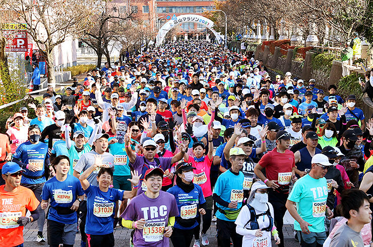「富山マラソン２０２１」で、次々にスタートする大勢のランナーたち＝高岡市役所前