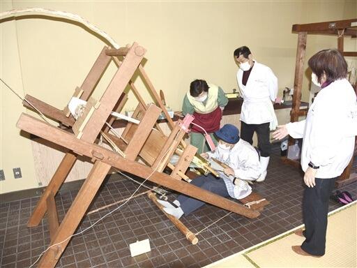昔ながらの織機の実演を眺める来場者ら＝１１月１３日、福井県勝山市の「織機資料館」