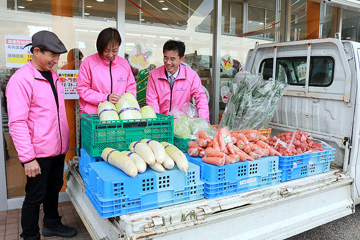 軽トラで販売する野菜と清原さん（左）ら