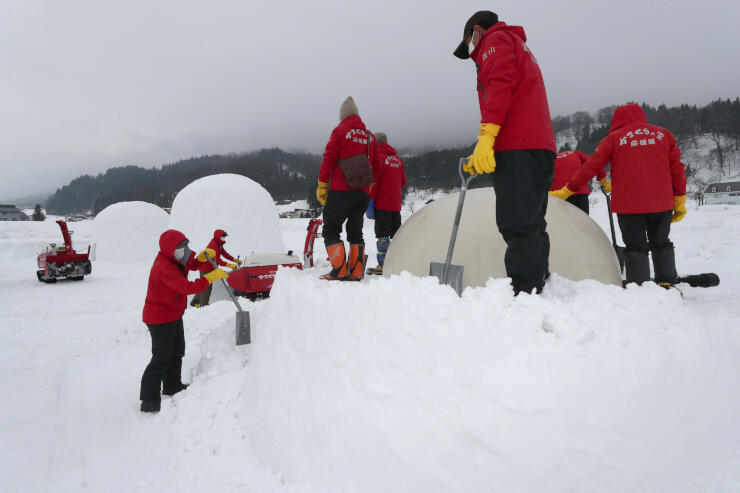 かまくら応援隊のメンバーが着々と雪を固め、かまくらを造っていった＝１１日午後２時７分、飯山市寿