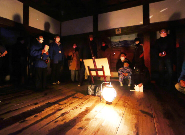 松本城天守内でちょうちんの明かりを体験する参加者＝１３日午後６時４１分、松本市