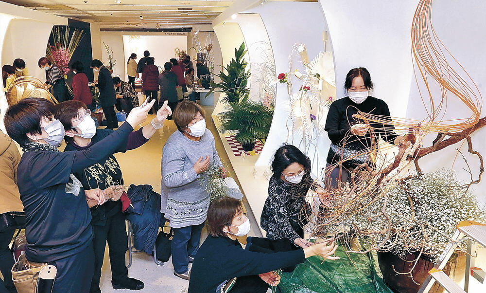 間隔を空けて行われた北國花展後期展の生け込み。出品者は集中して意欲作を仕上げた＝金沢市の金沢エムザ８階催事場