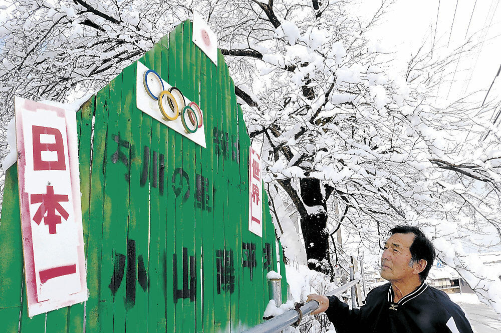 竹の断面で五輪マークを作り、看板に掲げた元尾さん＝金沢市三小牛町