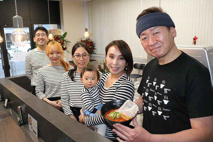 日本橋兜町の店でナポらー麺を手にする久保社長（右）ら