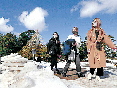 青空に映える、雪の兼六園　観光客が散策
