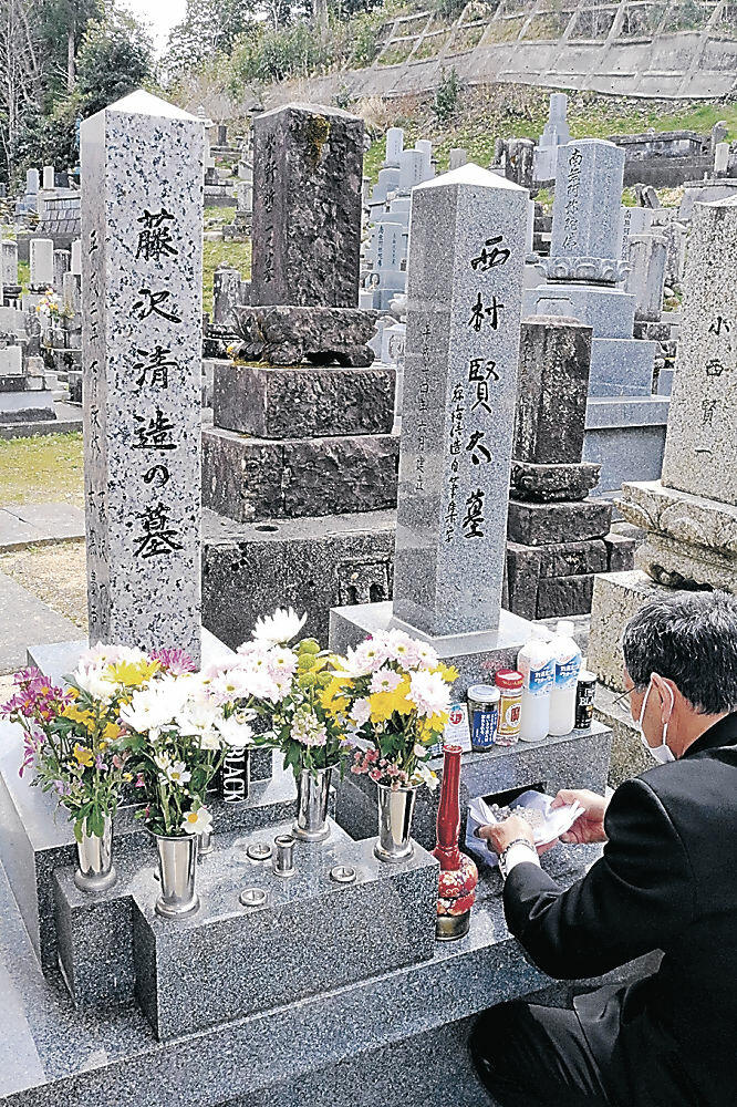 西村さんの遺骨を納める参列者＝七尾市小島町の西光寺