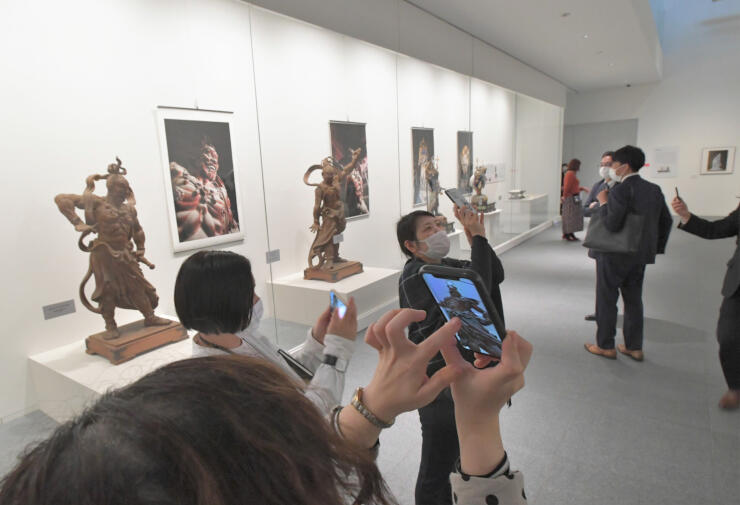 仁王像などのひな型が展示される「善光寺さんと高村光雲」展。スマホで仁王像のＡＲ画像を楽しめる＝１日、長野市の県立美術館