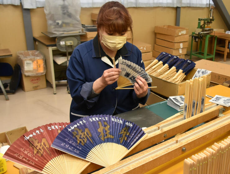 御柱祭を記念した扇子を作る平井星光堂さくら工場の従業員