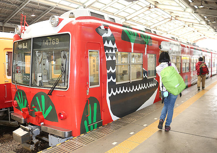 ライチョウが描かれたラッピング電車に乗り込む観光客＝電鉄富山駅