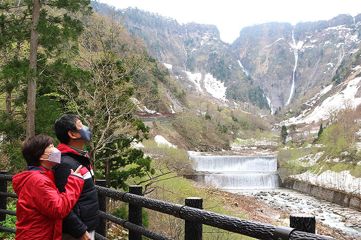 駐車場近くの展望台で絶景を楽しむ観光客。称名滝とハンノキ滝を見ることができた