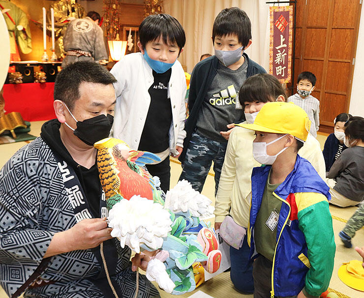 上新町公民館で、曳山の彫刻を見学する児童