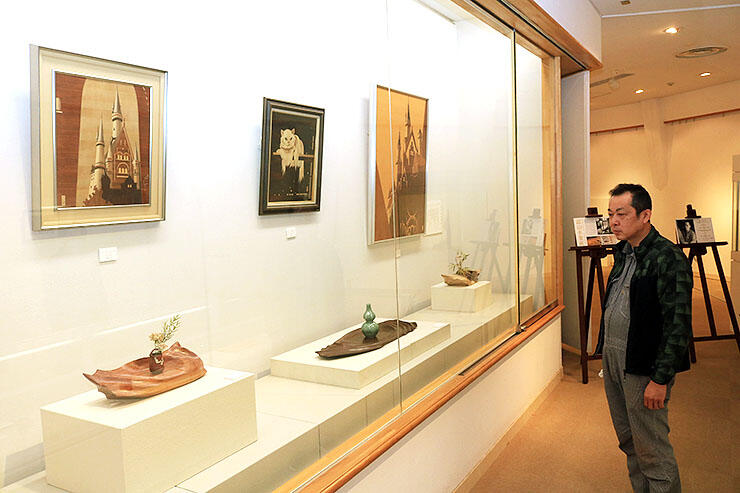 寺さん（右）が制作した花台や、富山木象嵌のパネルが並ぶ会場＝高岡工芸高校青井記念館美術館
