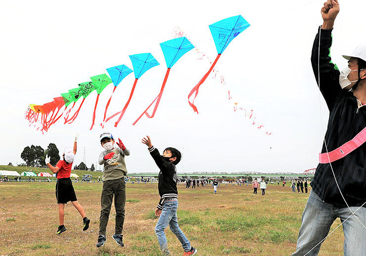 連凧を揚げて楽しむ地元児童ら＝射水市の庄川左岸河川敷
