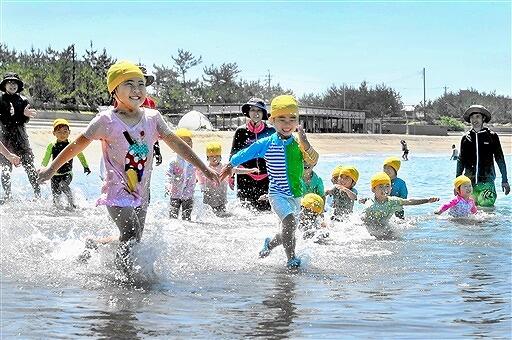 水しぶきを上げ、海に駆け出す園児たち＝７月１日、福井県坂井市の三国サンセットビーチ