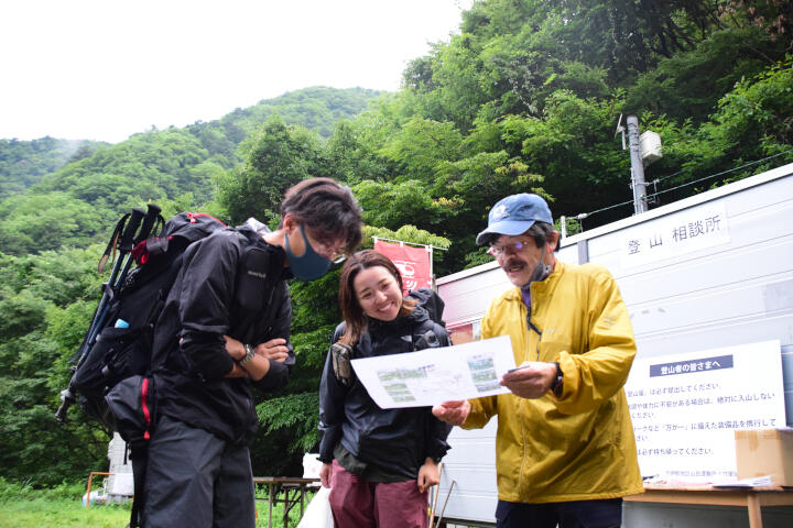 入山する登山者に遭難しやすい場所を説明する大蔵さん（右）＝１６日、飯田市南信濃