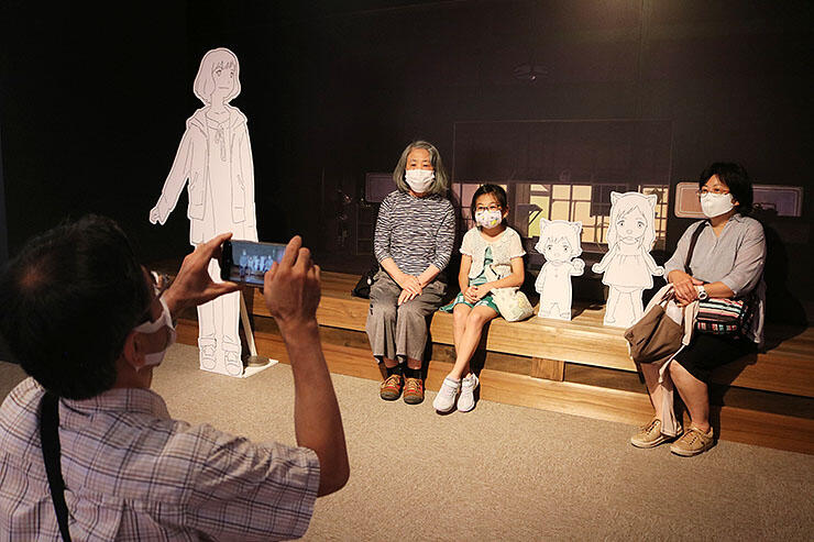 西田美術館の企画展の記念撮影コーナーで写真を撮る家族連れ
