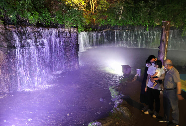 幻想的にライトアップされた白糸の滝＝２９日午後７時４８分、軽井沢町