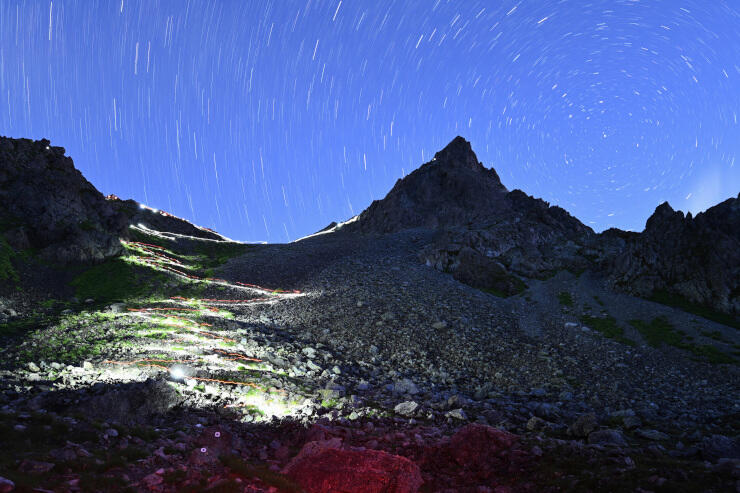 槍ケ岳山頂に向かう登山者のヘッドライトで暗闇に浮かび上がった登山道＝３１日午前３時４０分から１５分の長時間露光で撮影