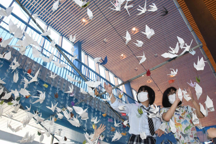 飯山駅につるす折り鶴を確認する生徒ら