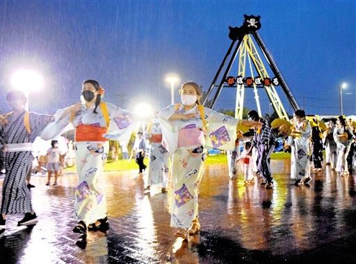 雨の中、約１３０人が参加した「ふるさと踊り」＝８月１４日夜、福井県越前市武生中央公園