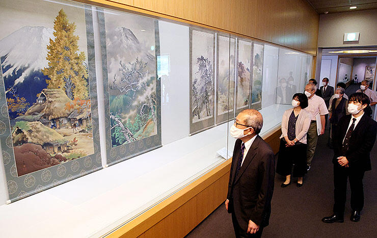 富士山の雄大な姿を描いた「富士二題」に見入る関係者