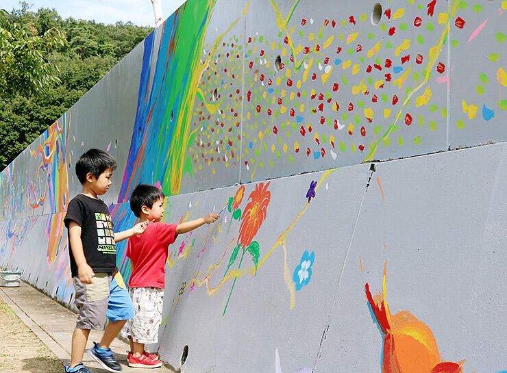 高さ約２メートルの壁に絵を描く子ども