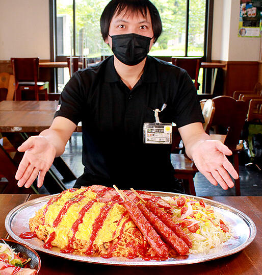 総重量約５キロの「ＧＩＧＡナポ飯」を紹介する荒井さん＝宇奈月麦酒館