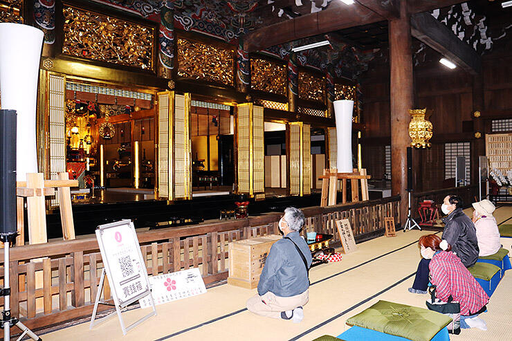 ツアーで勝興寺を訪れる観光客ら