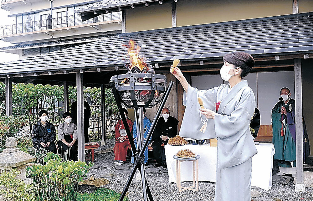 茶筅を火にくべる関係者＝七尾市和倉温泉