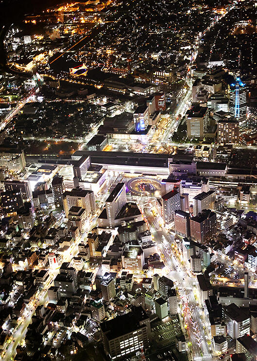 イルミネーションやビルの明かりが輝く富山駅（中央）周辺＝８日午後５時４０分ごろ、富山市上空