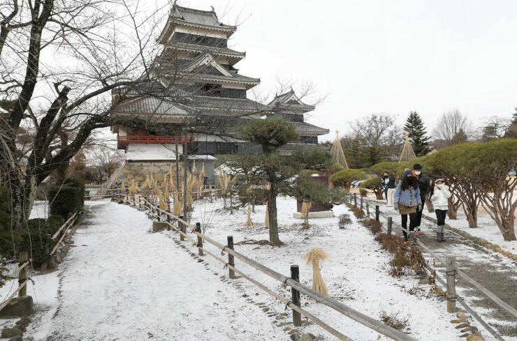 うっすらと雪化粧した松本城本丸庭園。タイからの観光客らも雪景色を楽しんだ＝２３日午前１０時１４分