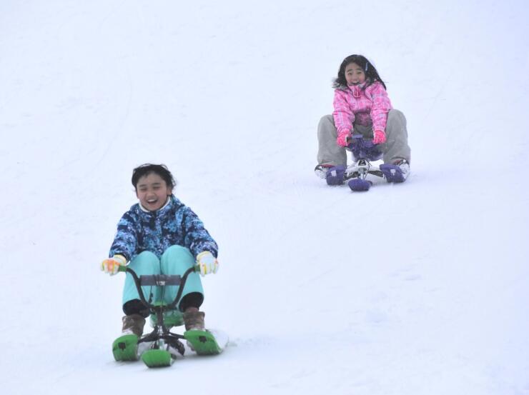 「スノーレーサー」で滑る子どもたち