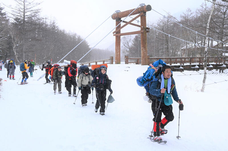 新年を北アルプスで迎えようと河童橋前の雪道を進む登山者ら＝３０日午前１０時２３分、松本市安曇の上高地