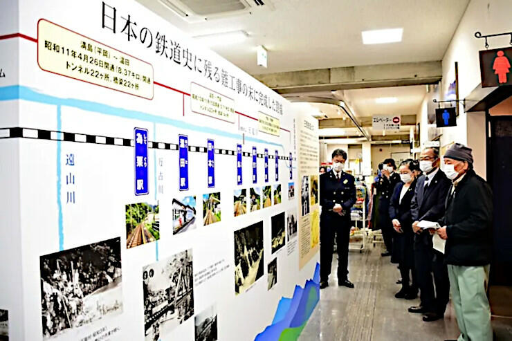 パネルを見ながら飯田線の歴史を解説する野竹さん（右）