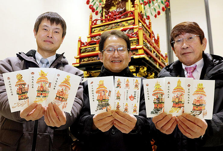 ポストカードを手にする（左から）針山会長、安田さん、井上さん＝伏木コミュニティセンター