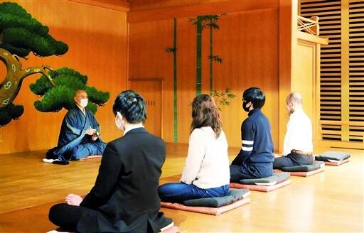 能舞台で座禅を体験する参加者＝２月２２日、福井県福井市のハピリンホール