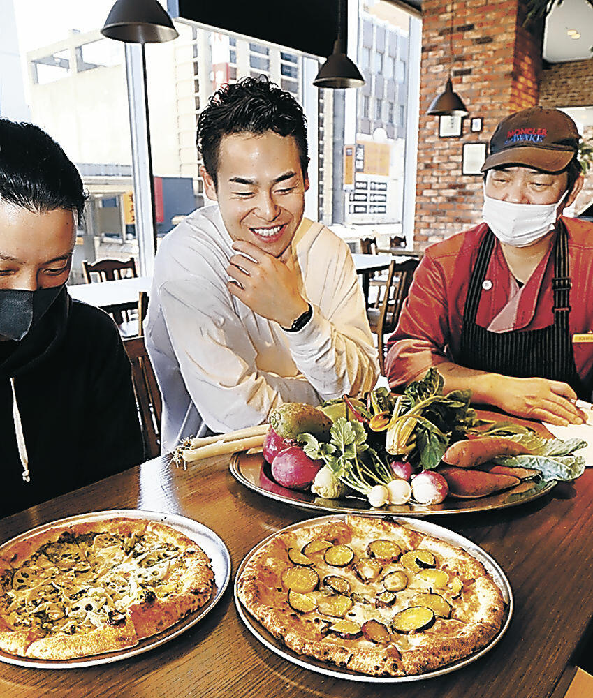 地元野菜を使ったピザを試食する関係者＝金沢市内の飲食店