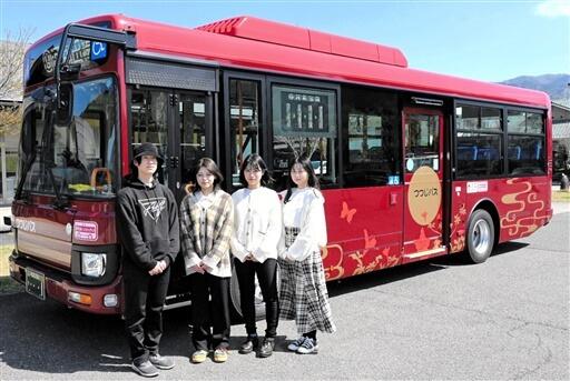 福井工業大の山口さん（右から２人目）がデザインしたつつじバス＝３月２９日、福井県鯖江市うるしの里会館