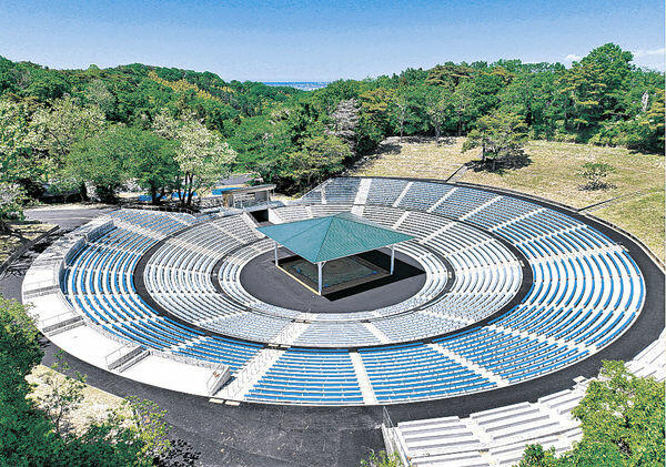 改修が終わった石川県卯辰山相撲場。新緑に囲まれ、青を基調とした新たな観客席が目を引く＝金沢市末広町（ドローンで撮影）