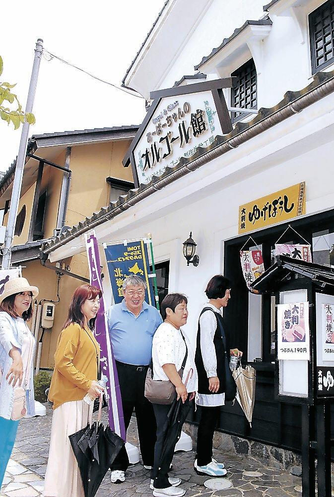新設した大判焼きの店を観光客にＰＲする吉田さん（左から３人目）＝加賀市山中温泉南町