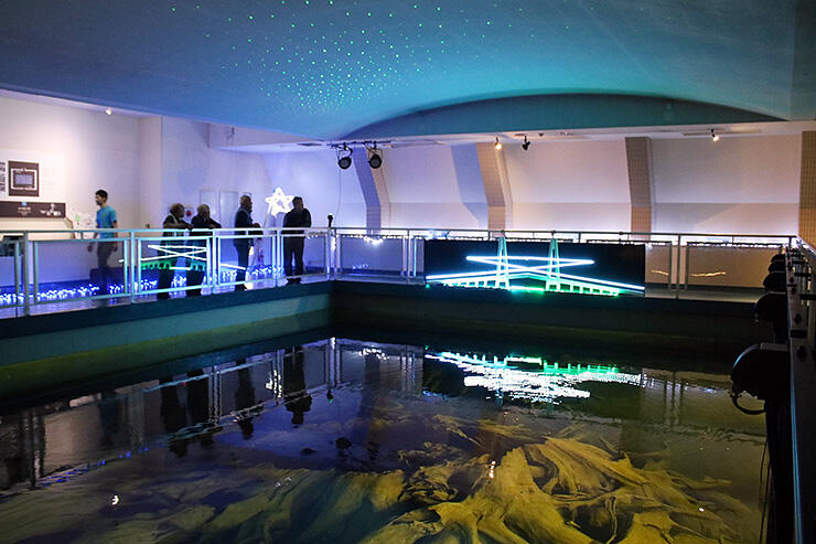 埋没林が保存・展示されている水中展示館で、夜の蜃気楼を再現したイルミネーションを試験点灯させる関係者