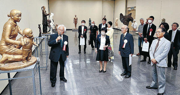 山田理事長（左）の解説に聞き入る開場式出席者＝石川県立美術館
